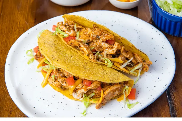 Chicken tacos with crisp shells and fresh toppings.